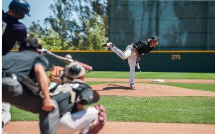 A baseball pitcher with his leg in the air immediately after throwing a baseball to a batter.