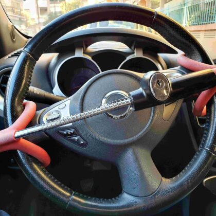 A steering wheel inside of a car has an anti-theft lock as the car remains empty and stationary in the middle of the day.