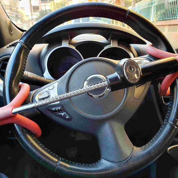 A steering wheel inside of a car has an anti-theft lock as the car remains empty and stationary in the middle of the day.