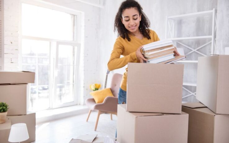 A young college student packing her belongings into moving boxes as she gets ready for a big move.