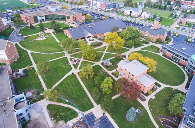 An aerial view of a college campus in Northeast Indiana with interconnected footpaths and large trees.