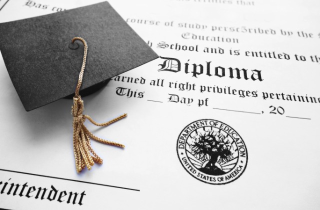 A school diploma certificate with decorative borders, printed text, and a seal displayed on a flat surface.